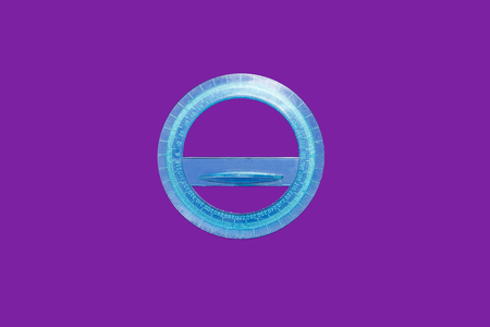 blue round plastic ruler lying on a purple background . concept of office supplies. free space for...