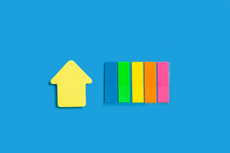 two different sticky note blocks lying isolated on blue background. concept of office stationary. free space for advertising textの写真素材