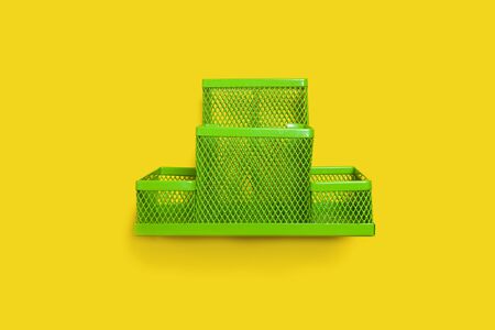 green pencil holder standing isolated on the yellow background. concept of office or school suppliesの写真素材