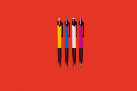 Four colored pens lying on redの写真素材