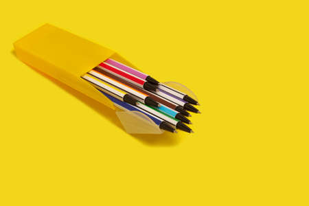 colored pens in a yellow box. office accessories. schoolの写真素材