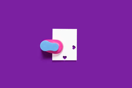 hole puncher with a paper on a purple backgroundの写真素材