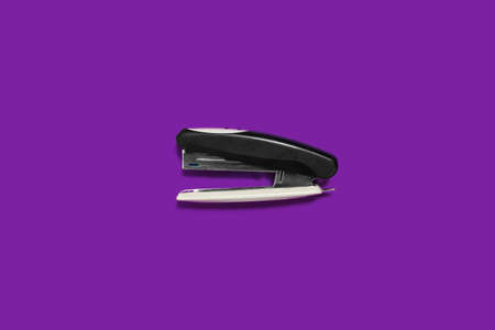 black stapler isolated on a purple background