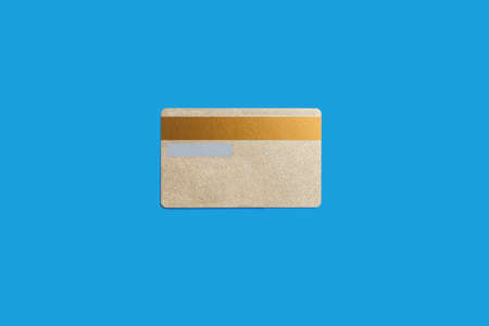 Gold credit card isolated on the blue backgroundの写真素材