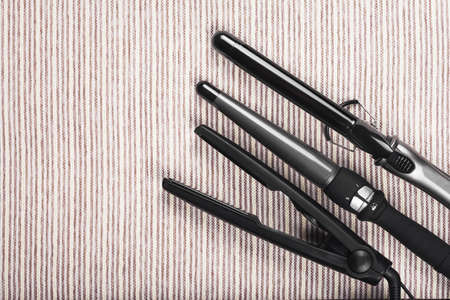 set of various hair straightening tools on gray striped backgroundの写真素材