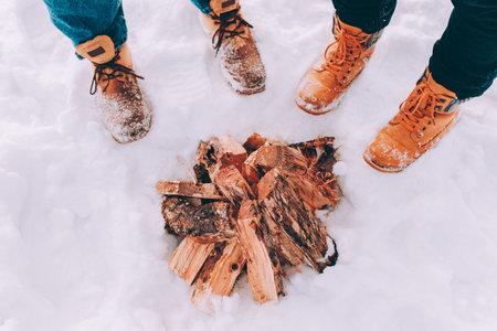 Two people stand in the snow near campfire. Winter themeの写真素材