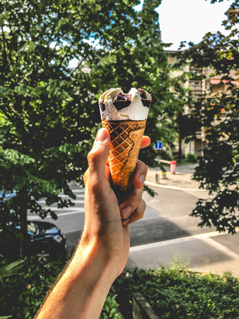Woman Holding Ice Cream Cone Against Trees