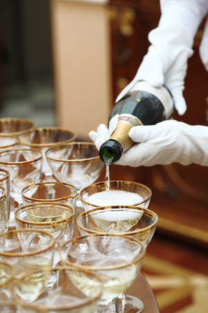 waiters in white gloves poured champagne glasses on the tableの写真素材