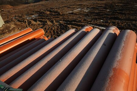 Red plastic water pipes at a construction siteの写真素材