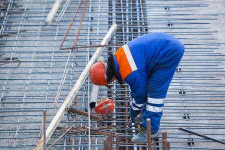 Construction Worker connects rebar at a construction siteの写真素材
