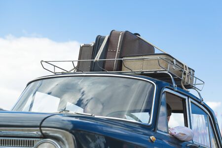Vintage suitcases on the roof of the trunk of a car.の写真素材