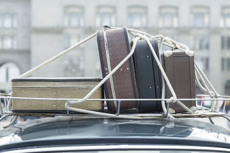 Vintage suitcases on the roof of the trunk of a car.の写真素材