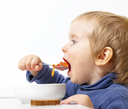 Baby eats vegetable soup spoonの写真素材