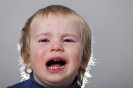 portrait of emotional tears crying baby toddler blond long hairの写真素材