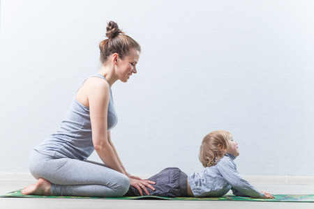 Hatha yoga fitness mother with baby.の写真素材