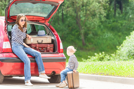Girl happy child travel suitcases car summer landscapeの写真素材