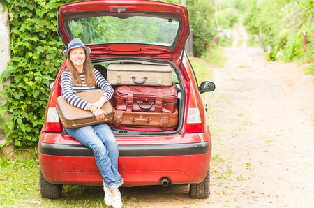 Girl happy child travel suitcases car summer landscapeの写真素材