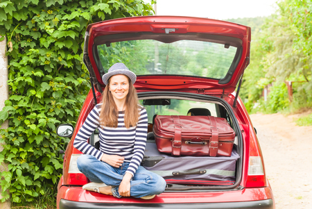 Girl happy child travel suitcases car summer landscapeの写真素材