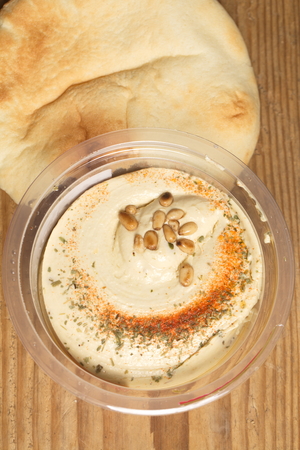 Hummus with cedar nuts in the jar and fresh pitaの写真素材