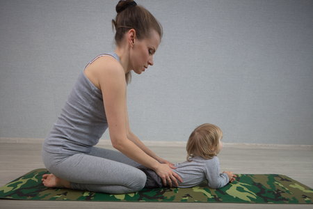 Hatha yoga fitness mother with babyの写真素材