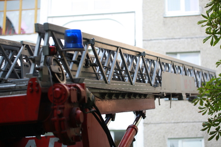 The ladder of a fire engine to a burning house