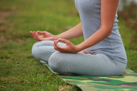 Young woman is engaged in hatha yoga in the mountains in the morning in a fogの写真素材