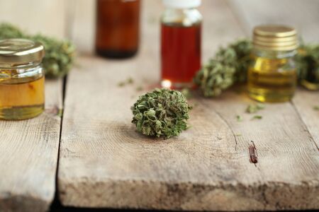 Green leaves of medicinal cannabis with extract oil on a wooden table. alternative medicineの写真素材