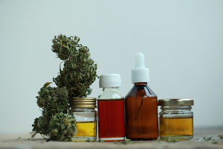 Green leaves of medicinal cannabis with extract oil on a wooden table. alternative medicineの写真素材
