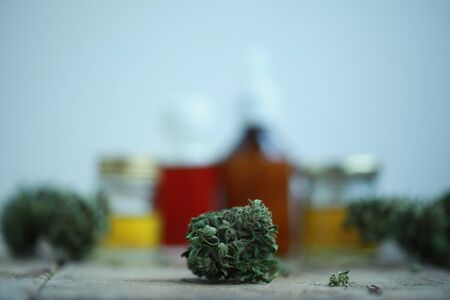 Green leaves of medicinal cannabis with extract oil on a wooden table. alternative medicineの写真素材