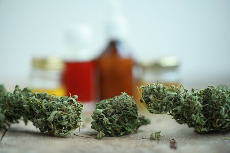 Green leaves of medicinal cannabis with extract oil on a wooden table. alternative medicineの写真素材