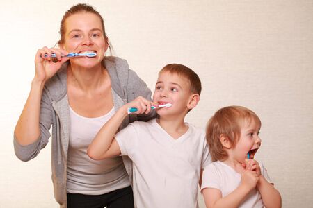 family mom and two blond boys brush their teethの写真素材