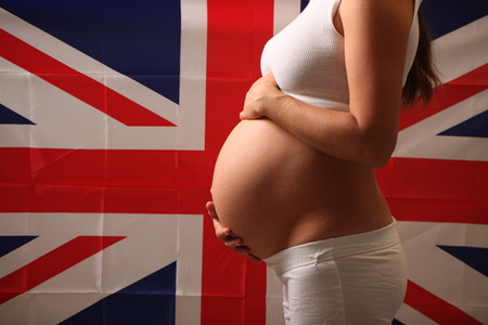 Fertility in the United Kingdom concept of a pregnant girl and English flagの写真素材