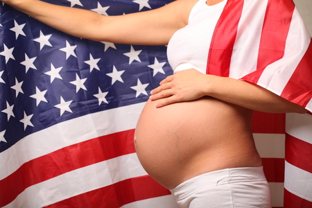 Fertility in america concept pregnant girl and american flagの写真素材