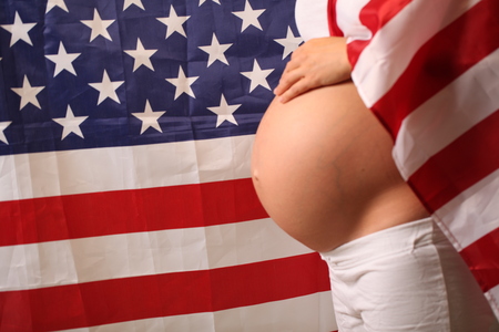 Fertility in america concept pregnant girl and american flagの写真素材