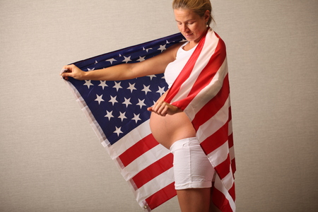 Fertility in america concept pregnant girl and american flagの写真素材