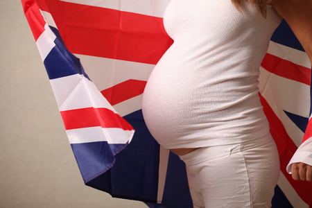 Fertility in the United Kingdom concept of a pregnant girl and English flagの写真素材
