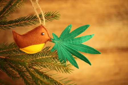 handmade toy on the Christmas tree. cannabis leaf in the bird's beak. Cannabis marijuana new year entertainmentの写真素材