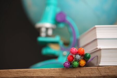 Concert education globe books microscope and pencils on background.
