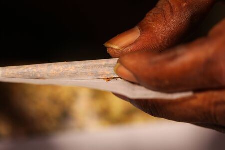 black man hands rolled marijuana joint close up
