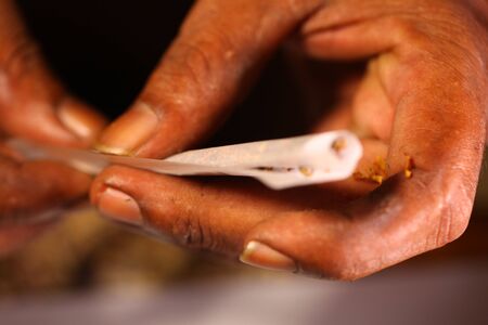 black man hands rolled marijuana joint close upの写真素材