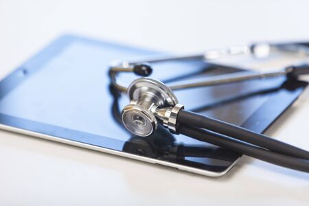 Tablet computer and stethoscope on the table. Online medicine.の写真素材
