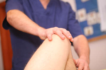 osteopath master massages the client's leg in the massage room