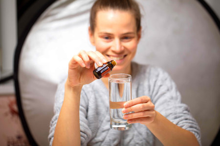 belarus, minsk, 2021. illustrative editorial doterra oil in hand womanのeditorial素材