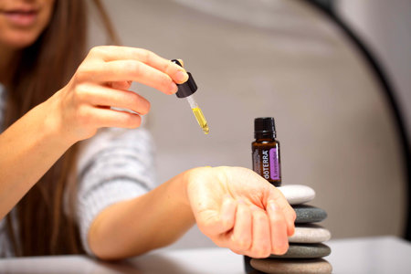 belarus, minsk, 2021. illustrative editorial doterra oil in hand womanのeditorial素材