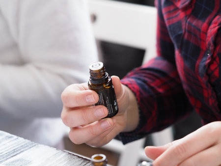 Close-up Of A Woman's Hand Holding A Bottle Of Essential Oilのeditorial素材