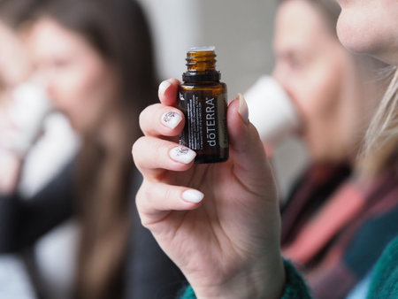 Close-up of a bottle of essential oil in a woman's hand.のeditorial素材