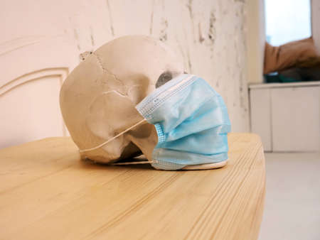 white plaster skull in a disposable mask