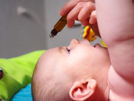 Mother used bottle roller therapeutic grade essential oils at a health lecture for newborn kidsの写真素材