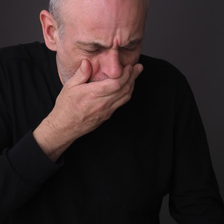 adult man with closed eyes emotion of pain on his faceの写真素材