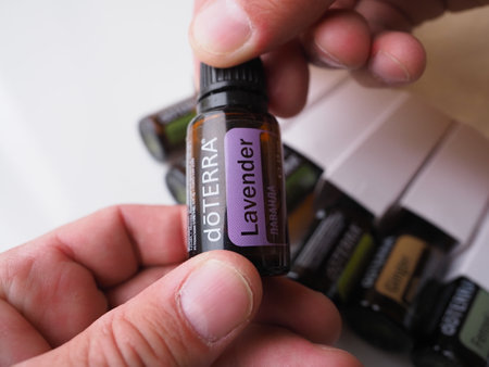 belarus, minsk, 2022. male hands open a glass branded bottle of Doterra essential oilのeditorial素材